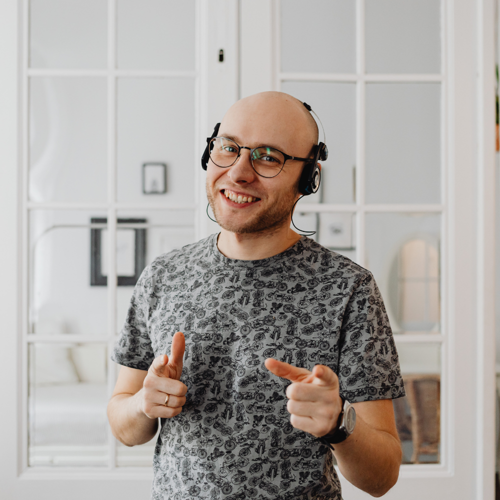 Man in grey patterned shirt wearing headphones