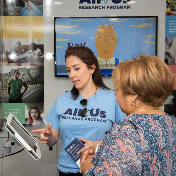 Brand ambassador on the All of Us Journey demonstrates how to use the enrollment kiosk touchscreen.