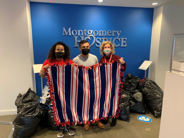 Montage team members holding a blanket made for community members in need during the Montgomery County Volunteer Center's MLK Week of Service.