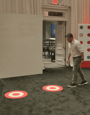 A man skipping between bullseyes (the Target logo) to light up different inspiring statements on the kinetic affirmation wall.