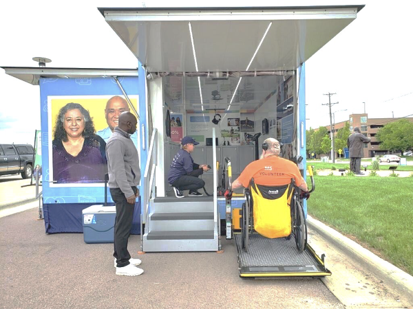 A volunteer uses the ADA-compliant electric wheelchair lift on the All of Us Journey vehicle.